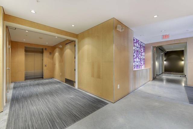 corridor featuring recessed lighting, elevator, and finished concrete flooring