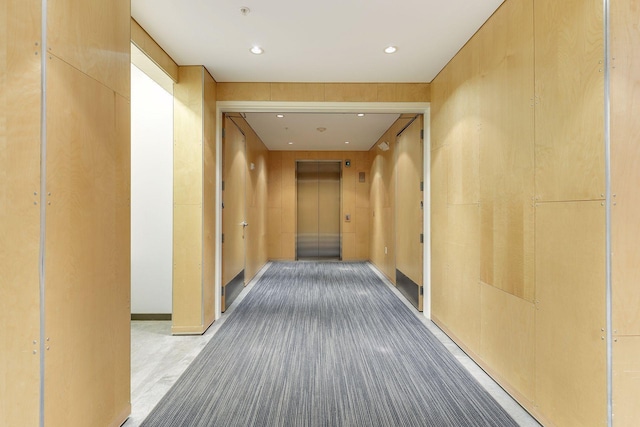 corridor with recessed lighting and elevator