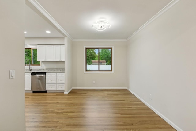 kitchen featuring stainless steel dishwasher, crown molding, white cabinetry, light wood-type flooring, and baseboards