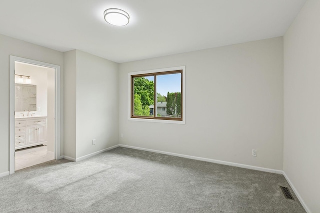 unfurnished bedroom with carpet, a sink, baseboards, and connected bathroom