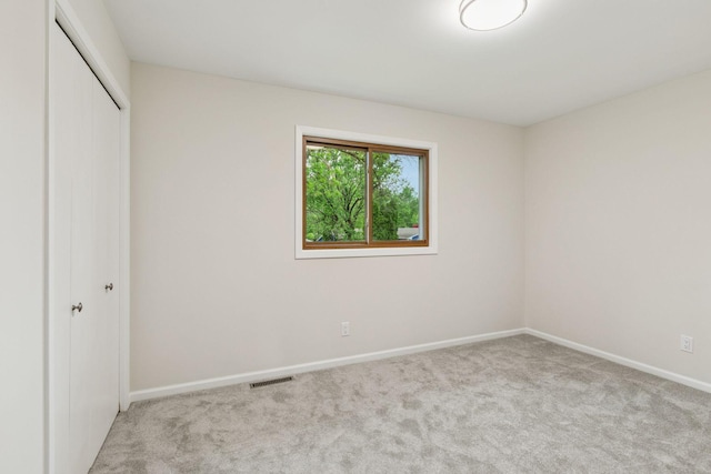 unfurnished bedroom with carpet floors, baseboards, and a closet