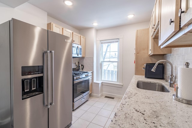 351 Morse Ave, Excelsior, MN 55331 - kitchen featuring appliances with stainless steel finishes, a sink, light brown cabinets, backsplash, and light tile patterned flooring