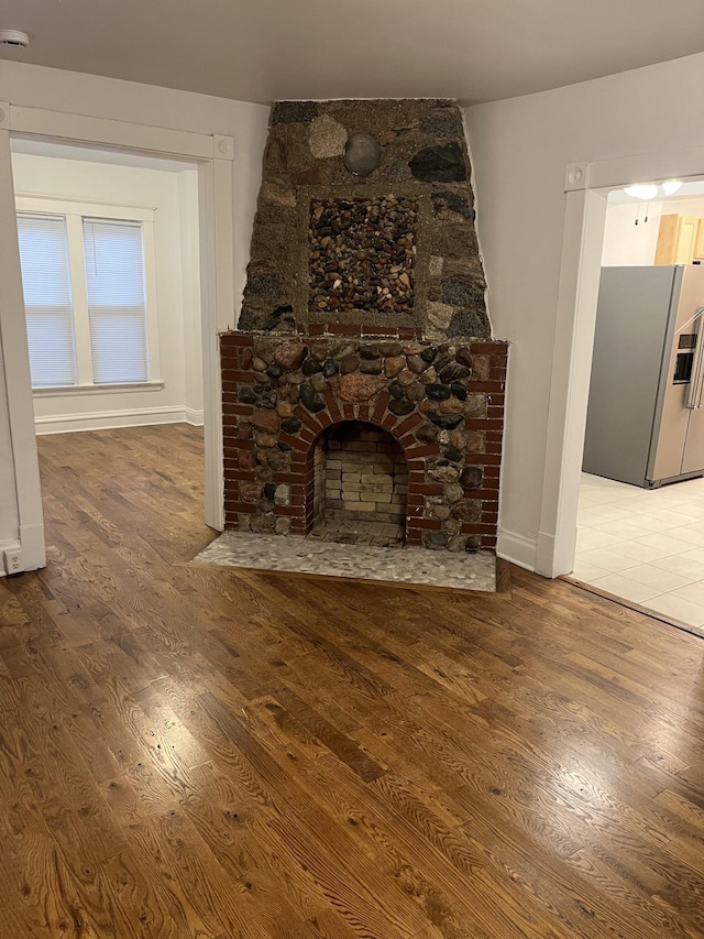 351 Morse Ave, Excelsior, MN 55331 - unfurnished living room featuring wood finished floors, baseboards, and a stone fireplace