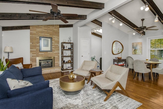 living room featuring wood-type flooring, a large fireplace, and lofted ceiling with beams