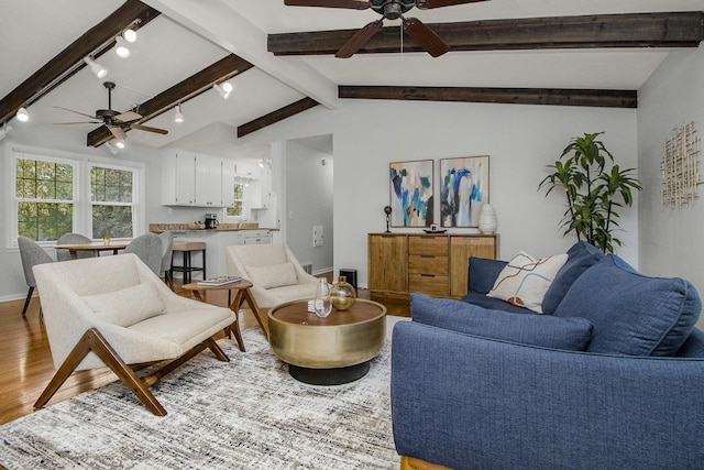 living room with light wood-type flooring, vaulted ceiling with beams, rail lighting, and ceiling fan