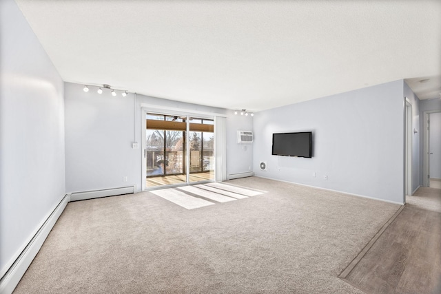 unfurnished living room with a wall unit AC, a baseboard heating unit, and light colored carpet