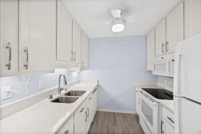 kitchen featuring hardwood / wood-style flooring, sink, white appliances, and white cabinets