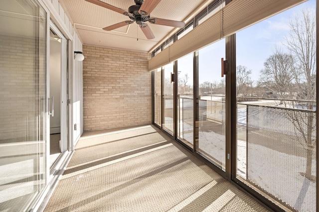 unfurnished sunroom with ceiling fan