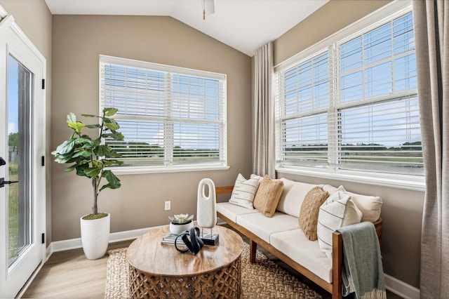 living room featuring ceiling fan, light wood-type flooring, and vaulted ceiling