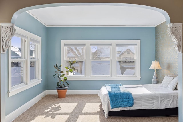 bedroom with arched walkways, carpet floors, ornamental molding, and baseboards