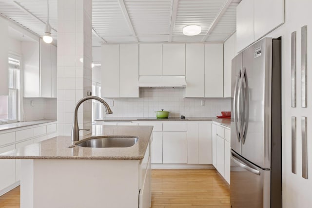 1625 25th St, Minneapolis, MN 55405 - kitchen with freestanding refrigerator, a sink, white cabinets, and light wood finished floors