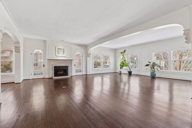1625 25th St, Minneapolis, MN 55405 - unfurnished living room featuring wood finished floors, a warm lit fireplace, arched walkways, baseboards, and crown molding