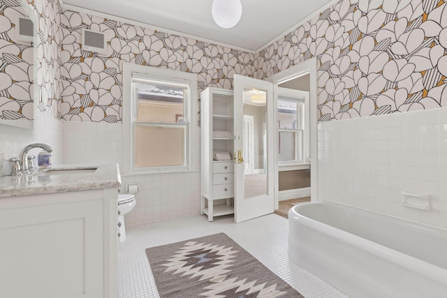 1625 25th St, Minneapolis, MN 55405 - bathroom featuring wallpapered walls, tile walls, a bath, tile patterned floors, and vanity