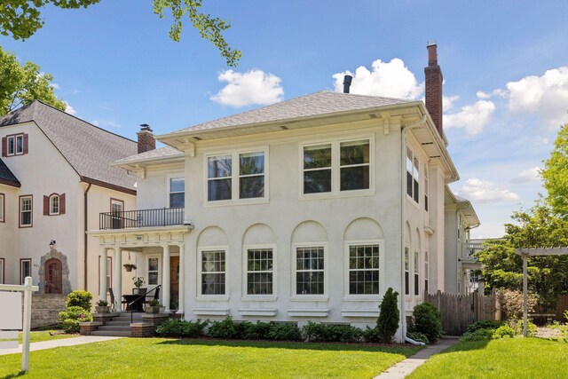1625 25th St, Minneapolis, MN 55405 - rear view of house featuring a balcony, a chimney, and stucco siding
