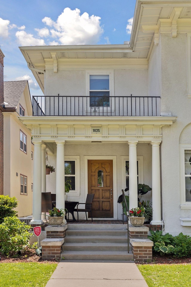 1625 25th St, Minneapolis, MN 55405 - entrance to property with a balcony, covered porch, and stucco siding