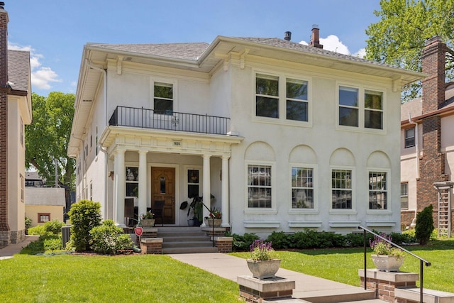 1625 25th St, Minneapolis, MN 55405 - back of house with a balcony, a lawn, stucco siding, and covered porch