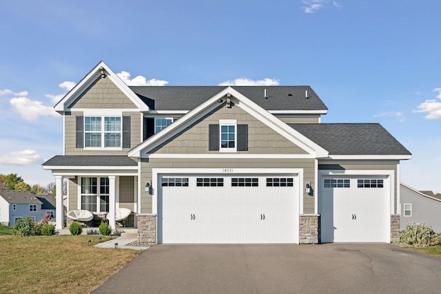 craftsman house featuring a front yard and a garage