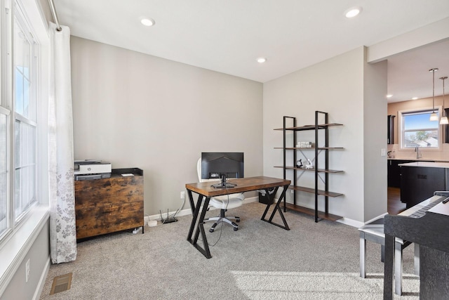 carpeted home office featuring sink