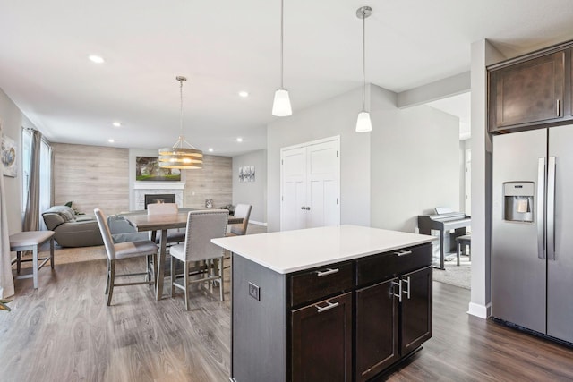 kitchen with pendant lighting, stainless steel fridge, dark brown cabinetry, and a center island