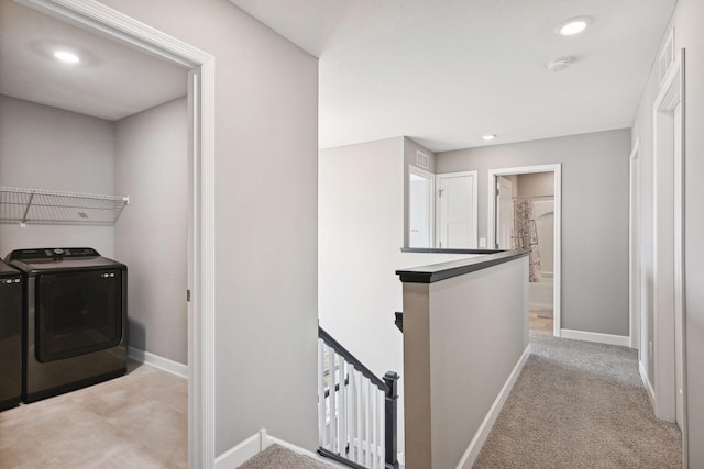 clothes washing area featuring separate washer and dryer and light colored carpet