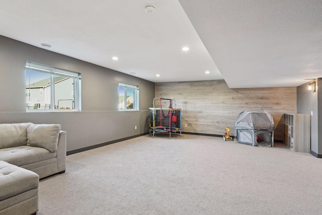 game room with carpet flooring and wood walls