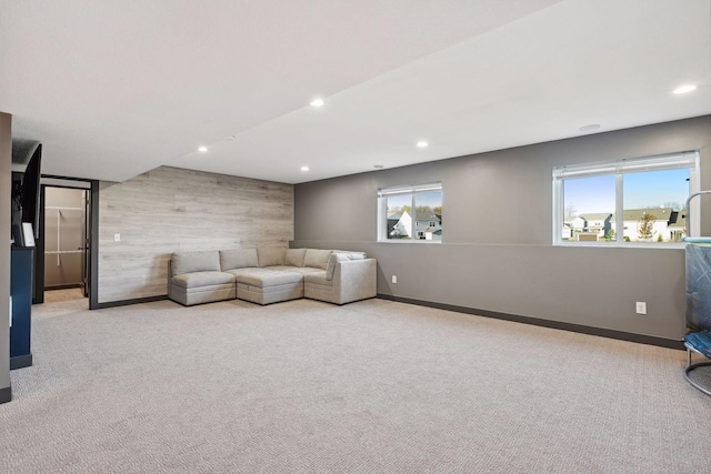 unfurnished room featuring wooden walls and light colored carpet