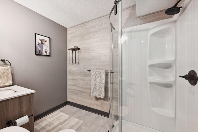 bathroom featuring a shower with shower door, wood walls, toilet, a textured ceiling, and vanity