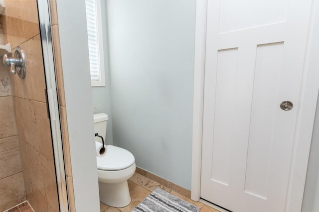 full bath featuring baseboards, a shower stall, toilet, and tile patterned floors