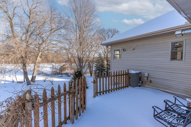 yard covered in snow with central AC unit and fence