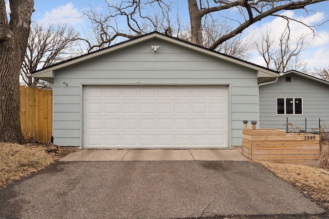 garage with driveway and fence