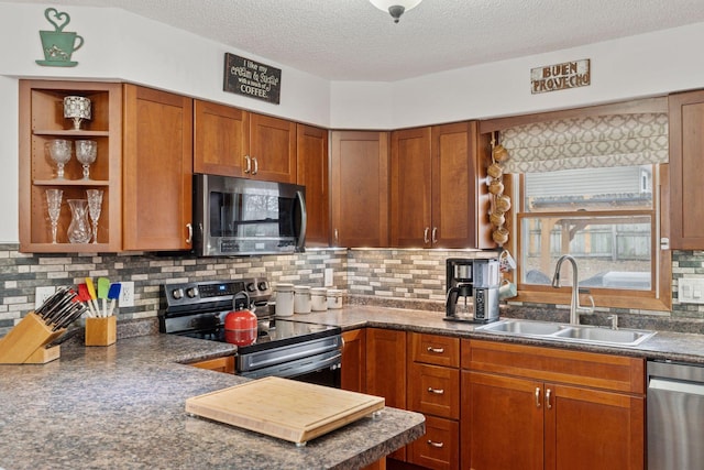 kitchen with open shelves, dark countertops, decorative backsplash, appliances with stainless steel finishes, and a sink