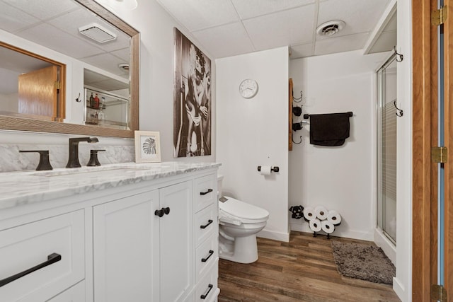 full bathroom with toilet, wood finished floors, a shower stall, and visible vents