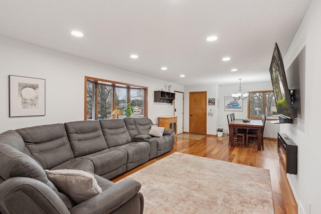 living room featuring light wood-type flooring, a notable chandelier, and recessed lighting