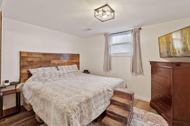 bedroom featuring dark wood-style flooring, visible vents, and baseboards