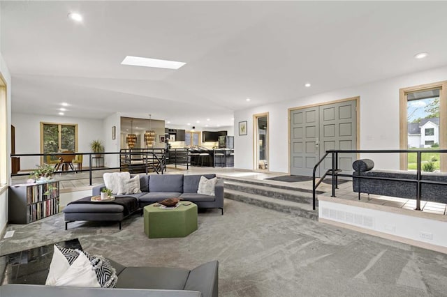 carpeted living room featuring recessed lighting and vaulted ceiling with skylight