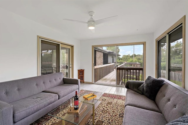 living area featuring light tile patterned floors, baseboards, and a ceiling fan