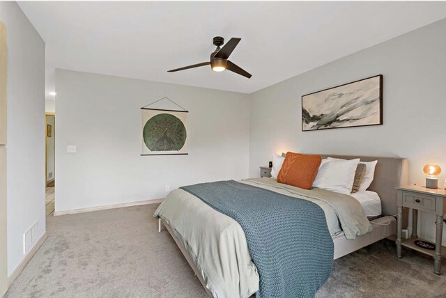 carpeted bedroom with visible vents, ceiling fan, and baseboards