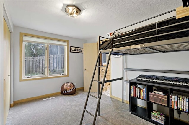 unfurnished bedroom with visible vents, baseboards, carpet, and a textured ceiling