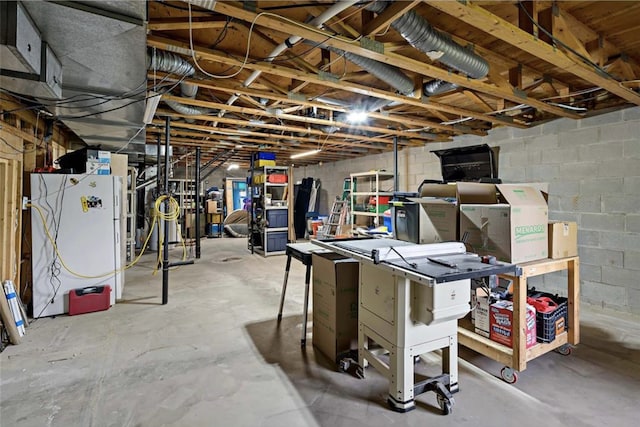 unfinished below grade area with concrete block wall and freestanding refrigerator