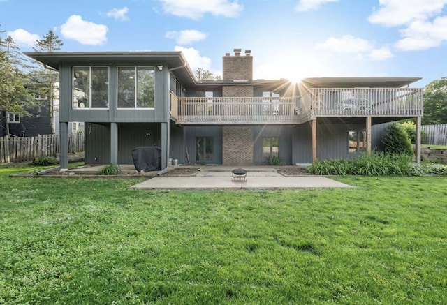 rear view of property with fence, a chimney, a lawn, and a patio area