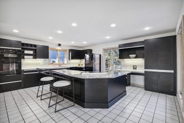 kitchen featuring black appliances, dark cabinetry, and open shelves