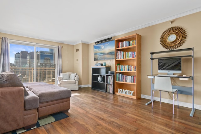 living room featuring baseboards, a view of city, ornamental molding, and wood finished floors