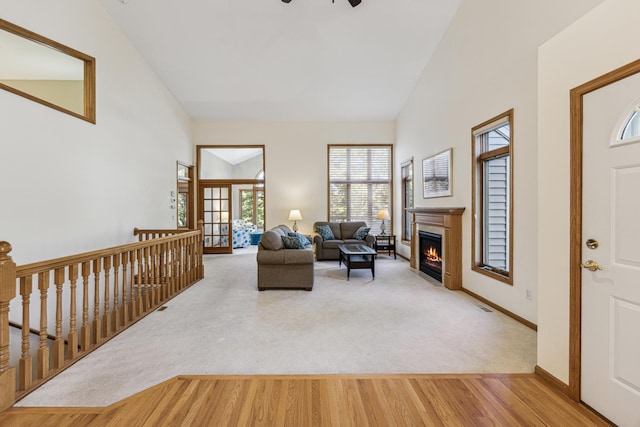 living room featuring high vaulted ceiling, ceiling fan, and wood-type flooring