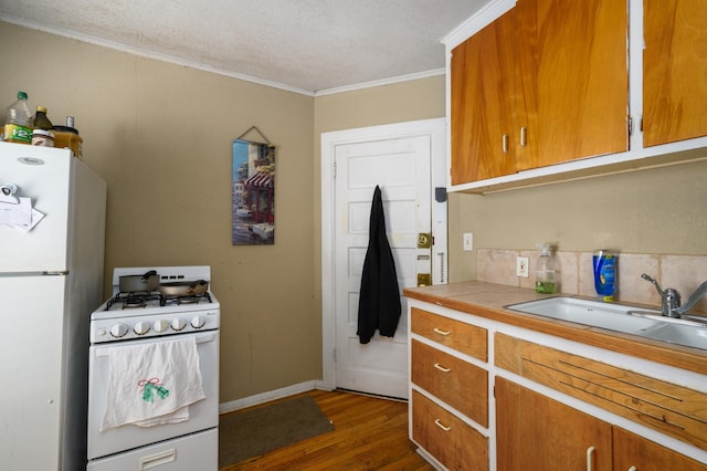 kitchen with sink, white appliances, tasteful backsplash, crown molding, and dark hardwood / wood-style floors