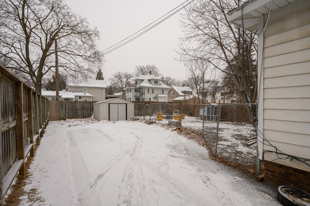 yard covered in snow featuring a shed