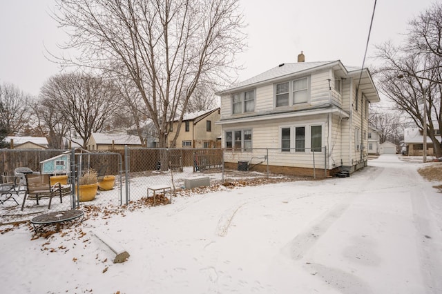 view of snow covered rear of property