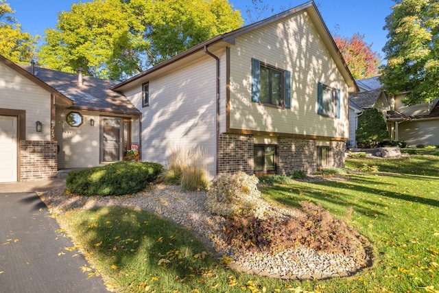 view of home's exterior with a yard and brick siding