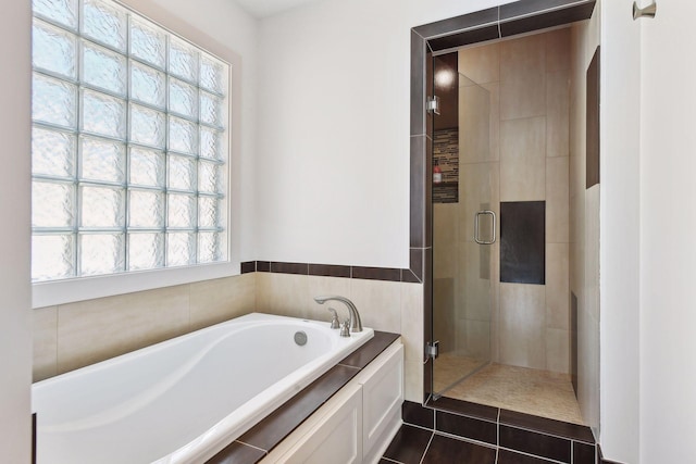 bathroom with a stall shower, a garden tub, and tile patterned floors