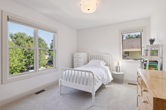 bedroom featuring carpet, baseboards, multiple windows, and visible vents