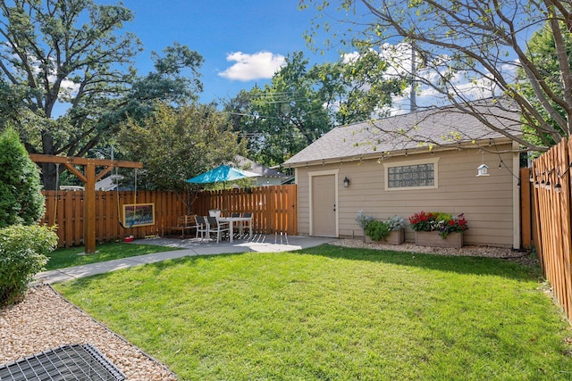 view of yard featuring an outbuilding, a patio, and a fenced backyard